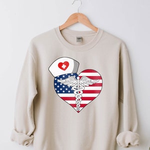 Sudadera con corazón de enfermera con la bandera estadounidense, regalo del 4 de julio para enfermeras, enfermeras registradas, enfermeras de la UCIN, enfermeras de urgencias, enfermeras de la UCI, ideas de regalos para paramédicos