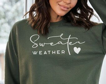 May include: A dark green sweatshirt with the text "Sweater Weather" and a white heart. The sweatshirt is made of a soft, comfortable material and has a relaxed fit.