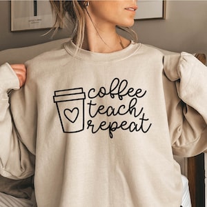 May include: A beige sweatshirt with the text "coffee teach repeat" and a drawing of a coffee cup with a heart on it.
