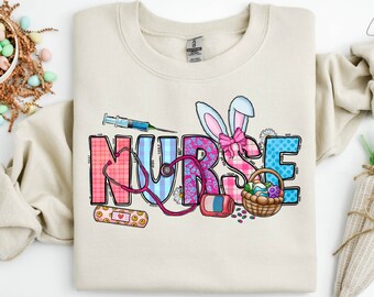 May include: A beige sweatshirt with a colorful graphic of the word "NURSE" decorated with Easter-themed elements like a bunny, eggs, and a stethoscope.