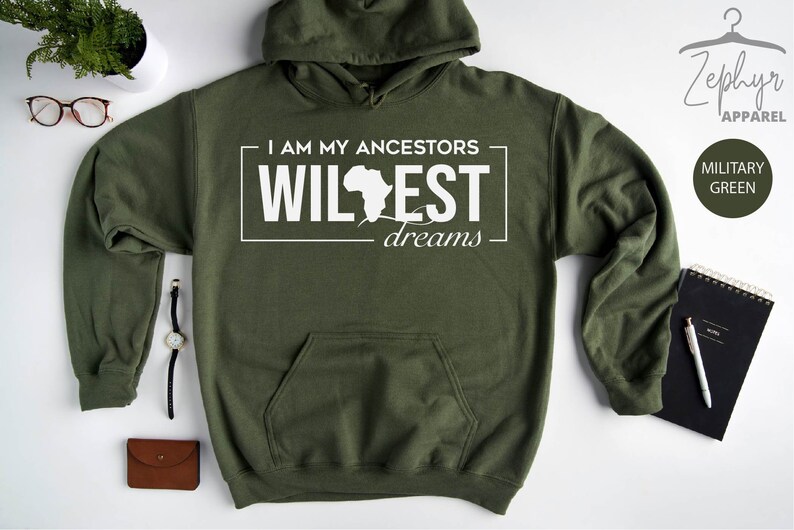 May include: A green hooded sweatshirt with a white graphic that says "I am my ancestors wildest dreams" with an outline of the continent of Africa.