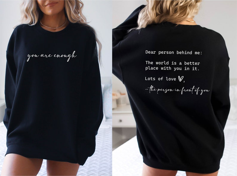 May include: Black sweatshirt with the text "you are enough" on the front and "Dear person behind me: The world is a better place with you in it. Lots of love - the person in front of you" on the back.