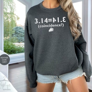 May include: Heather dark grey sweatshirt with the text "3.14=PI.E (coincidence?)" and a small pie slice graphic.