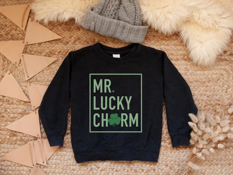 May include: Black sweatshirt with a green shamrock and the text "MR. LUCKY CHARM" in a white box.