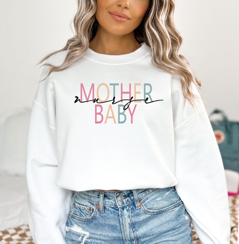 Puede incluir: Sudadera blanca con el texto "MOTHER nurse BABY" en letras de colores. El texto est&aacute; en un estilo de fuente moderno.