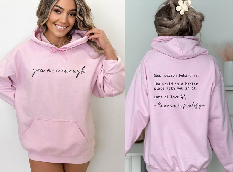 May include: Pink hoodie with the text "you are enough" on the front and "Dear person behind me: The world is a better place with you in it. Lots of love, - the person in front of you" on the back.
