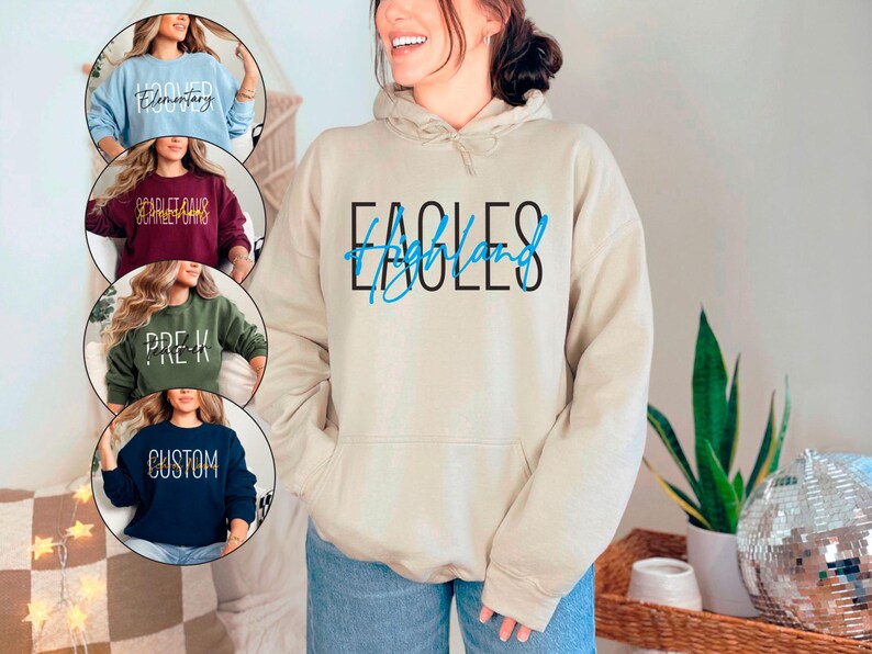 May include: A white hoodie with a blue and black graphic that says "Eagles of Highland". The hoodie has a drawstring hood and a kangaroo pocket.