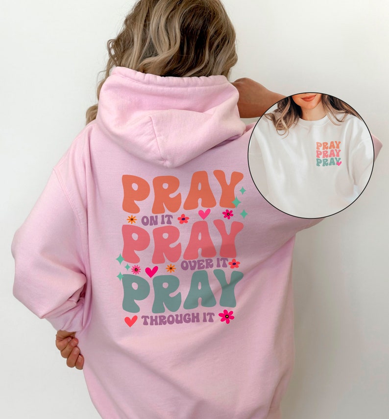 May include: Pink hoodie with a graphic on the back that says "Pray on it, Pray over it, Pray through it" in colourful, retro-style lettering with flowers and hearts.