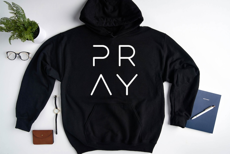May include: Black hoodie with a white graphic that says "PRAY" in a modern font.