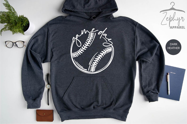 May include: Dark heather grey hoodie with a white baseball graphic and the text "game day" written in a script font.