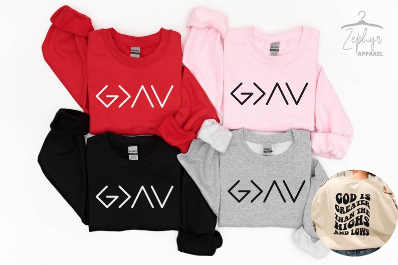 以下が含まれることがあります： 異なる色の4つのスウェットシャツに、前面に「G>V」という文字が印刷されています。ベージュのスウェットシャツには、背面に「神は高みと低みよりも偉大である」という文字が印刷されています。