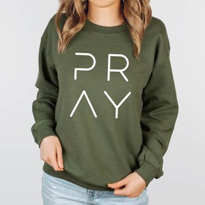May include: A green sweatshirt with the word "PRAY" printed in white on the front.