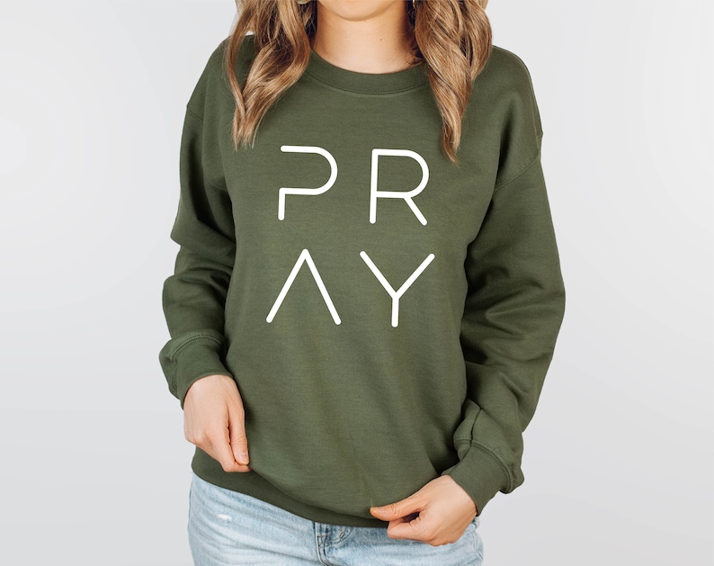 May include: A green sweatshirt with the word "PRAY" printed in white on the front.