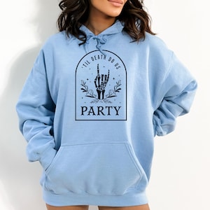 May include: Light blue hooded sweatshirt with a black graphic print of a skeleton hand making a rock and roll sign. The graphic also includes the text "'Til Death Do Us Party".