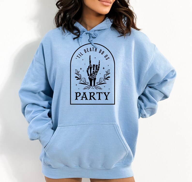 May include: Light blue hooded sweatshirt with a black graphic print of a skeleton hand making a rock and roll sign. The graphic also includes the text "'Til Death Do Us Party".