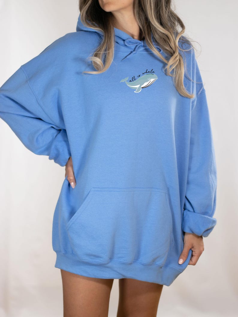May include: A light blue oversized hoodie with a whale graphic and the text "all is whale".