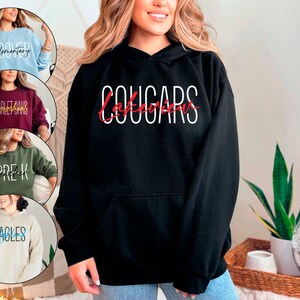 May include: Black hooded sweatshirt with the text "Lakeview Cougars" in white and red lettering.