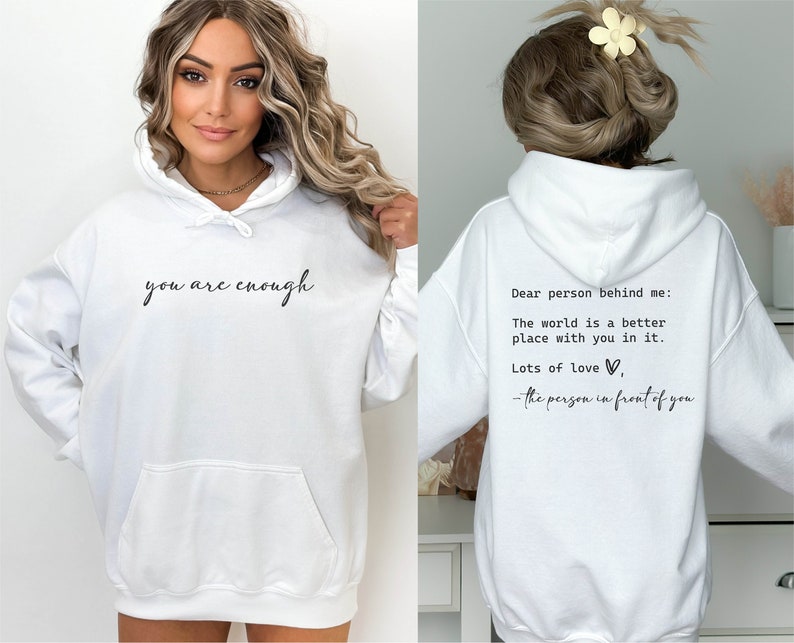 May include: White hooded sweatshirt with the text "you are enough" printed on the front and "Dear person behind me: The world is a better place with you in it. Lots of love, - the person in front of you" printed on the back.