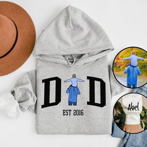 May include: Gray hooded sweatshirt with the word "DID" in black letters and the text "EST 2016" below. A small illustration of a father carrying a child on his shoulders is in the center of the word "DID".