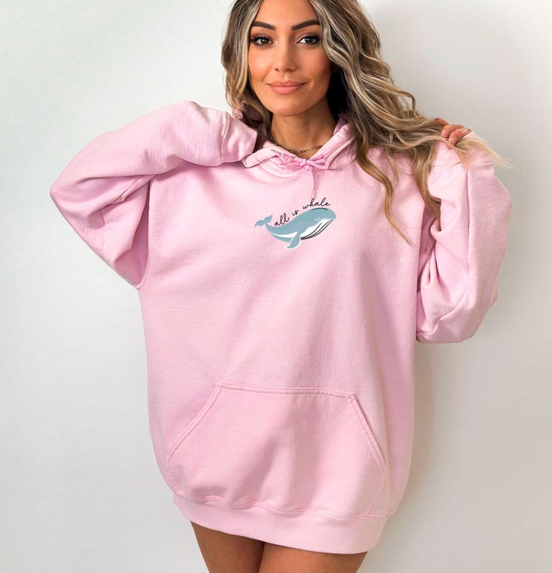May include: A pink oversized hoodie with a whale graphic and the text "all is whale" on the front.