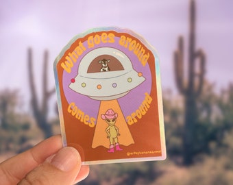 Ce qui se passe autour arrive, autocollant en vinyle holographique, cow-boy kidnappant un extraterrestre, ordinateur portable mignon et drôle, bouteille d’eau et décalcomanie de voiture