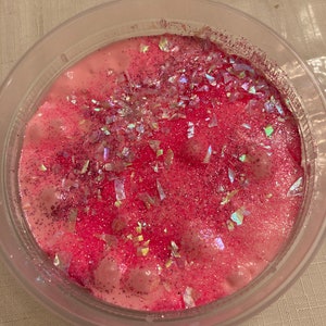 May include: Pink slime with iridescent glitter and white glitter in a clear plastic container.