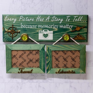 May include: Green wooden sign with the text "Every Picture Has A Story To Tell...because memories matter". The sign has a compass, a camera, and a plane on it. Two green wooden picture frames with the words "Travel" and "Adventure" are hanging below the sign.