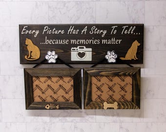 May include: A wooden sign with the text "Every Picture Has A Story To Tell... ...because memories matter". The sign has two photo frames with a paw print and a camera cutout on each side. The frames are brown and have a white background.