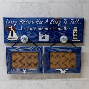 May include: A blue wooden sign with the text "Every Picture Has A Story To Tell... because memories matter". The sign has a sailboat, camera, and lighthouse graphic. Two blue wooden picture frames with white anchor and seagull graphics.