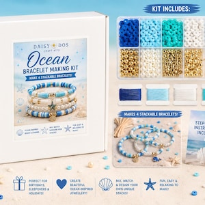 Peut inclure: Un kit de fabrication de bracelets Daisy Dos Ocean dans une boîte blanche, comprenant un récipient divisé de perles bleues, blanches et dorées, des breloques étoile de mer et baleine, quatre bobines de fil et une carte d'instructions.