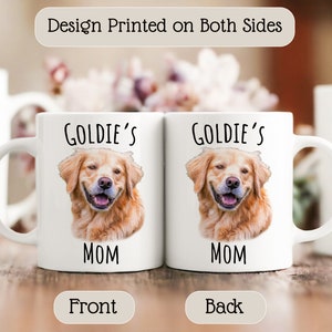 Op de afbeelding: Twee witte keramische mokken met een afbeelding van een golden retriever en de tekst "Goldie's Mom" erop. De mokken hebben een handvat aan de rechterkant. De tekst "Design Printed on Both Sides" staat bovenaan. De woorden "Front" en "Back" staan onderaan.