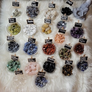 May include: Assortment of tumbled stones in small bowls, including Dalmatian Jasper, Blue Agate, White Quartz, Onyx, Green Opal, Howlite, Yellow Jasper, Rainbow Fluorite, Amethyst, Smokey Obsidian, Blue Quartz, Red Jasper, Sunstone, Unakite, Red Agate, Green Aventurine, Rose Quartz, Obsidian, Tigers Eye, Lapis Lazuli, Clear Quartz, and Sodalite.