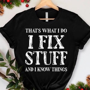 May include: Black t-shirt with white text that reads "That's what I do I fix stuff and I know things".