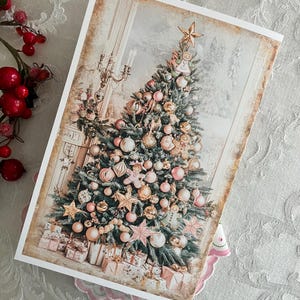 Op de afbeelding: Een kerstkaart met een versierde kerstboom met roze en gouden ballen, sterren en een ster op de top. De boom is omringd door ingepakte cadeaus. De kaart heeft een vintage esthetiek met een besneeuwde achtergrond en een decoratieve rand.