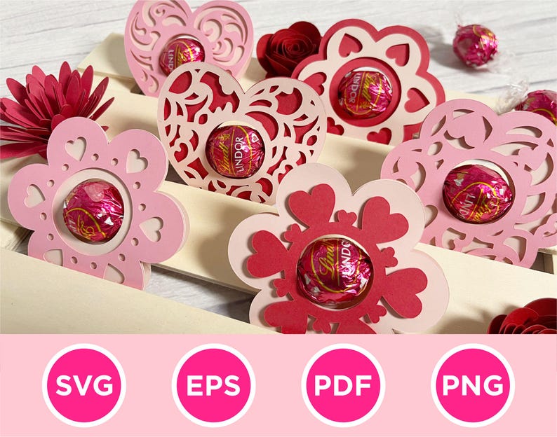 May include: Pink and red paper cutouts in heart and flower shapes, each holding a wrapped chocolate. The cutouts are arranged on a light-colored surface, with a paper flower and the words "SVG", "EPS", "PDF", and "PNG" in pink circles.
