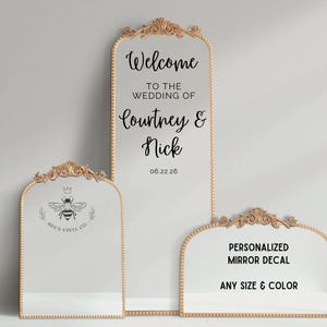 Könnte beinhalten: Drei dekorative Spiegel mit goldenen Rahmen. Der größte Spiegel trägt den Text "Welcome to the Wedding of Courtney & Nick 06.22.26". Der zweite Spiegel hat ein Bienenlogo und den Text "Bee's Vinyl Co.". Der dritte Spiegel trägt den Text "Personalized Mirror Decal Any Size & Color".