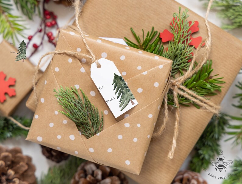 May include: Two brown gift boxes wrapped in white polka dot paper with twine and green sprigs. The top box has a white gift tag with a green watercolor tree and the words "To:" and "From:".