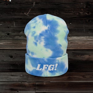 May include: A blue and green tie-dye beanie with the text "LGF!" embroidered in white.