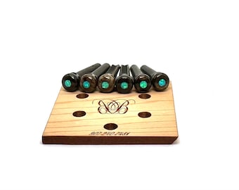 May include: Set of six guitar tuning pegs with turquoise inlay. The pegs are displayed on a wooden display stand with the text "MAY THE MUSIC PLAY" engraved on the stand.