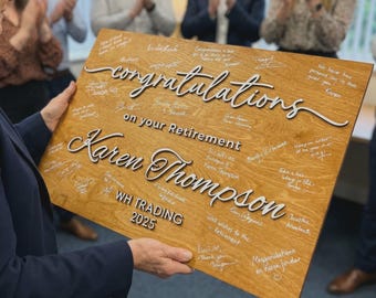 Puede incluir: Una placa de jubilación rectangular de madera con el texto blanco en 3D "congratulations on your Retirement" y "Karen Thompson", con "WH TRADING 2025" impreso debajo. La superficie está cubierta con numerosas firmas y mensajes escritos a mano.