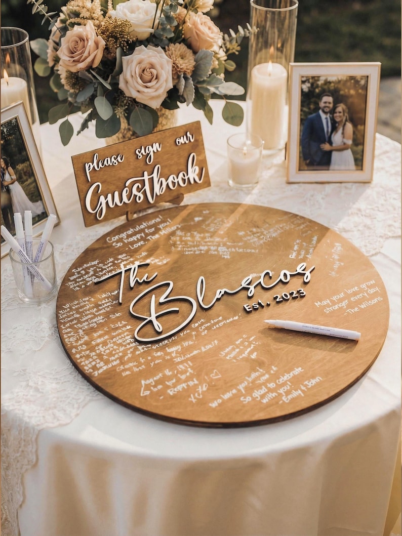 Rustic wooden wedding guestbook sign on table with please sign our guestbook sign, personalized round wood guest book alternative with engraved names and guest messages.