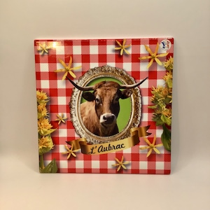 Französischer Vintage Keramik Hand verziert L&#39;Aubrac Untersetzer. Es hat eine Korkbasis, um Ihre Oberflächen zu schützen.