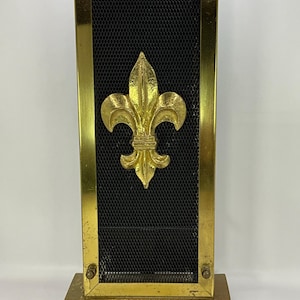 Peut inclure: Un écran de cheminée en métal doré avec une insertion en maille noire et un motif de fleur de lys dorée.