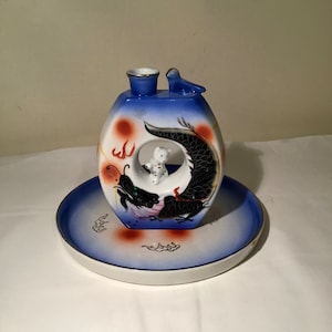 Asian vintage Sake decanter / carafe with tray. It is white, blue and red in colour with pictures of a dragon.