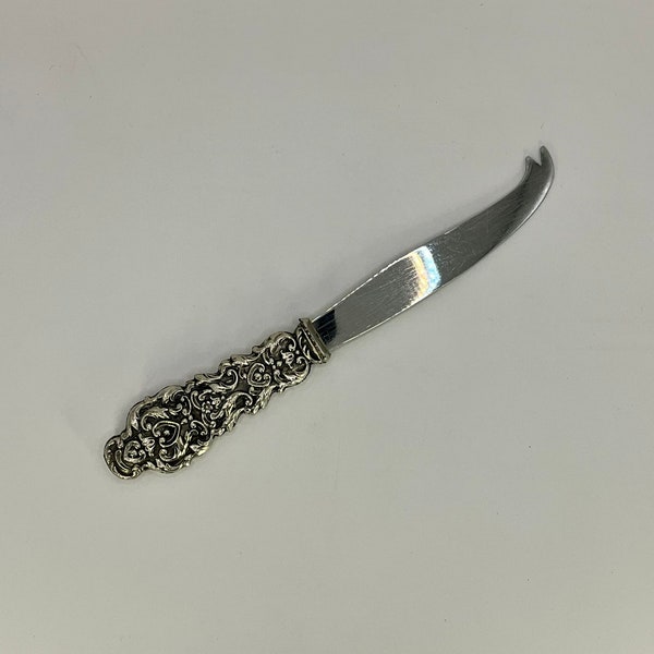 French vintage ornate silver metal butter and cheese knife. It has a nice ornate pattern on the handle.