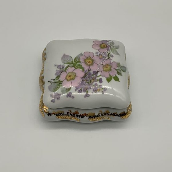 French vintage Limoges France porcelain ornamental trinket   box coloured with gold patterns and a floral lid.