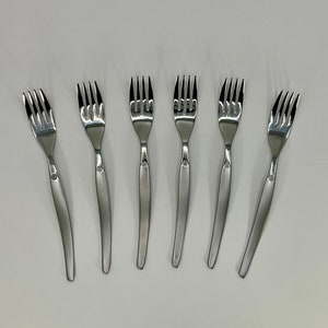 Puede incluir: Seis tenedores de plata con mango curvo y cuatro dientes.