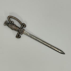 Precioso abrecartas en forma de espada de metal color plata adornado estilo vintage.