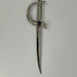 Impresionante abrecartas vintage francés bañado en plata, con una elegante forma de daga y con un patrón ornamentado.