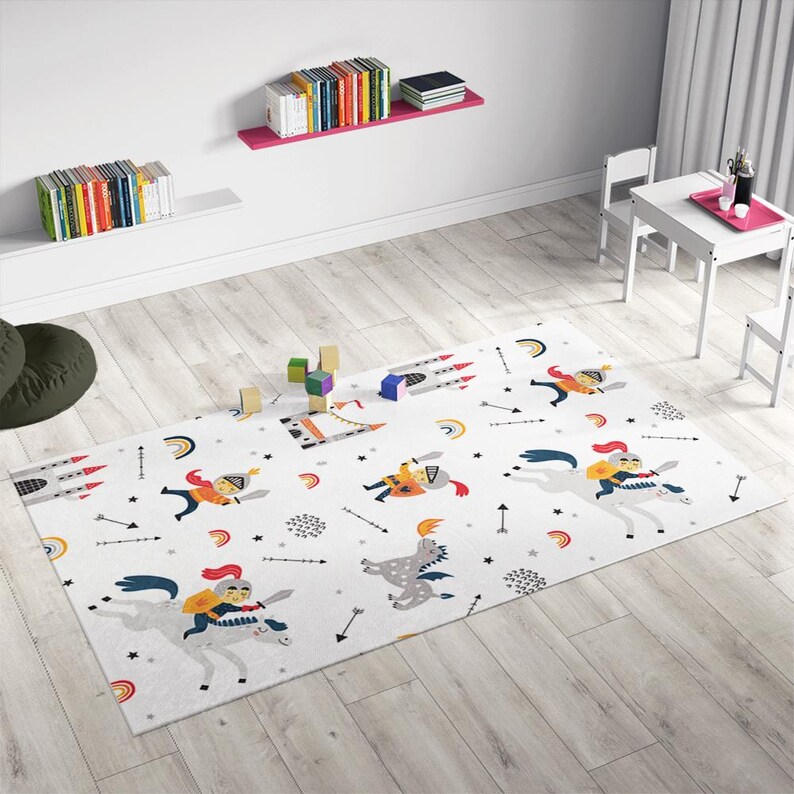 May include: A white play mat with a colorful knight and dragon design. The mat features knights riding horses, dragons, castles, rainbows, and arrows.